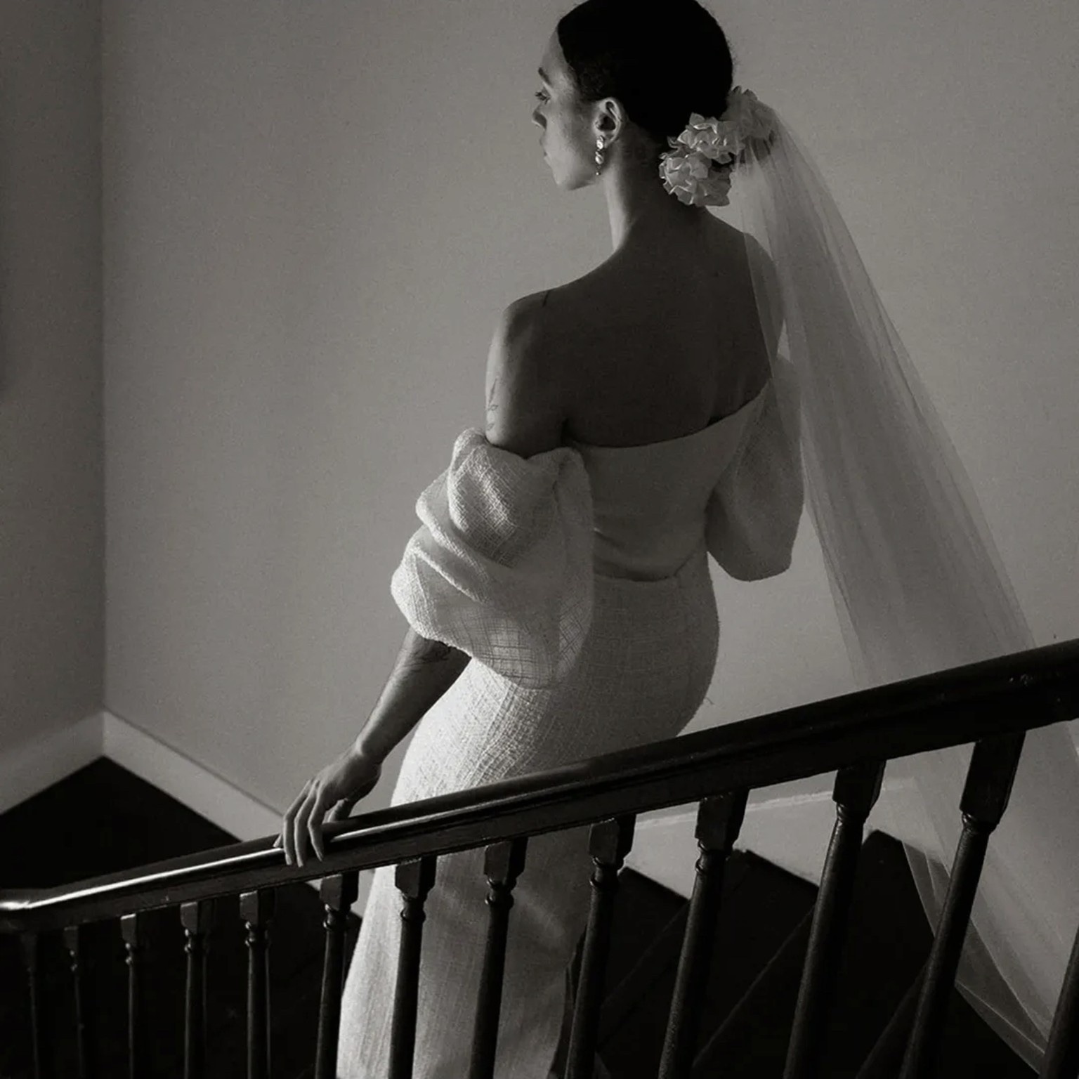 Bride wearing a Studio Nora bridal ensemble with veil and textured sleeves